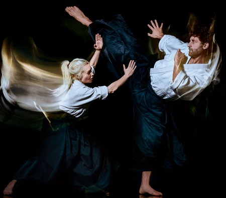 two bodokas fighters man and woman practicing Aikido studio shot isolated on black background