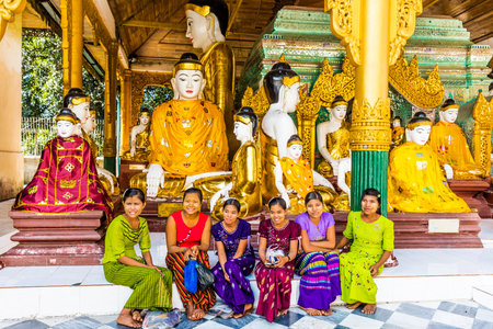 YANGON, MYANMAR - DECEMBER 16, 2016 : women posing in front Buddha statues of the Shwedagon Pagoda at Yangon (Rangoon) in Myanmar (Burma)のeditorial素材