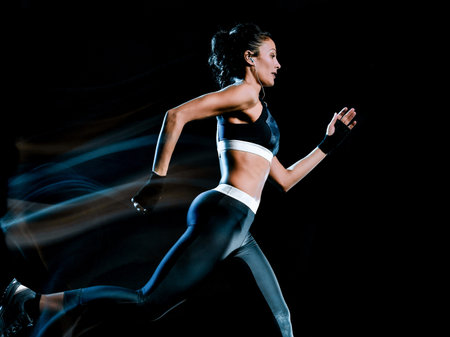 one beautiful caucasian mixed race woman unner jogger jogging running  in studio isolated on black...