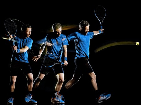 one caucasian tennis player man isolated black background in light painting speed motion multiple exposureの写真素材
