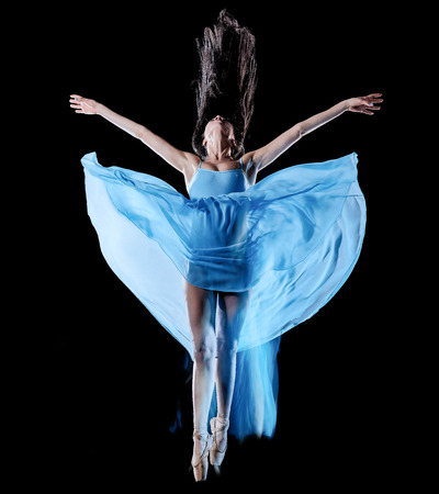 one caucasian young woman ballet dancer dancing isolated on black background with  light painting motion blur speed effectの写真素材