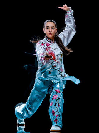 one chinese woman partacticing Tai Chi Chuan Tadjiquan posture studio shot isolated on black...