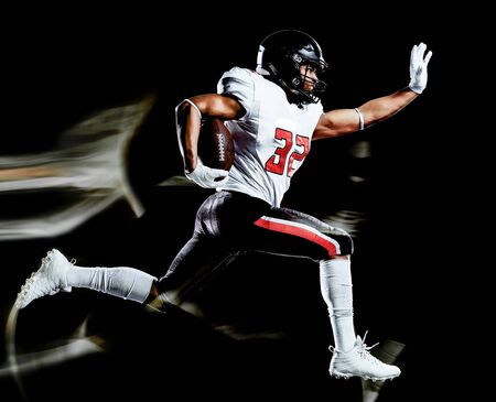 one african american football player man studio shot isolated on black background with light painting with blurred motion speed effectの写真素材