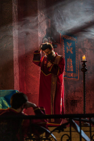 Tatev , Armenia - August 19, 2019 : priest praying at mass service at the Tatev monastery landmark...