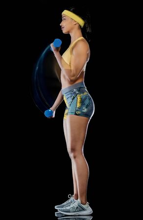 one mixed race woman exercising fitness exercises isolated on black background with lightpainting effectの写真素材
