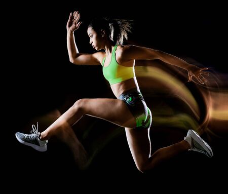 woman exercising fitness exercises isolated black background lightpainting effectの写真素材