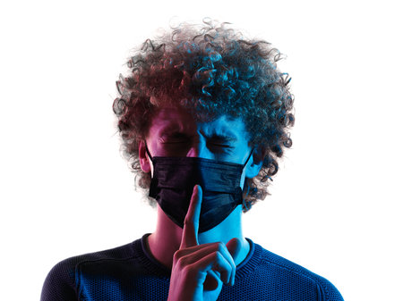 young man headshot face mask hushing silence portrait shadow white backgroundの写真素材