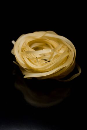 spaghetti nests with eggs for the design on a black backgroundの写真素材