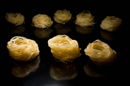 Three nests of spaghetti in the future with the rear black backgroundの写真素材