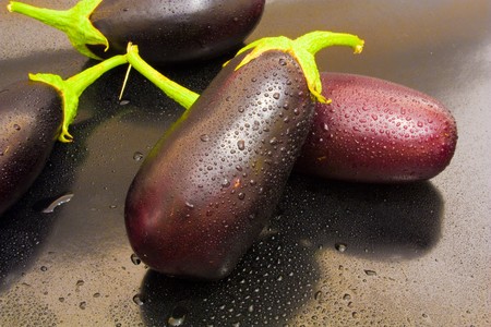Two eggplant in the center of juicy kali water on a black backgroundの写真素材