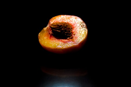 Half a peach notched bone with glitter on a black backgroundの写真素材