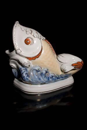 Porcelain sculpture of fish on a black backgroundの写真素材