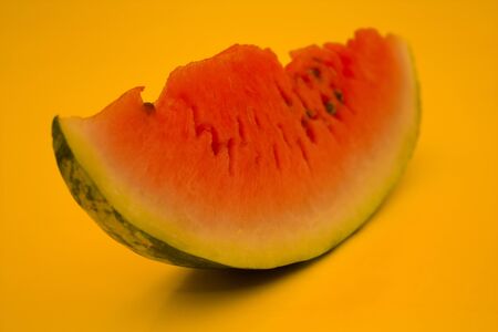 the only part of a slice of watermelon on a yellow background for the designの写真素材