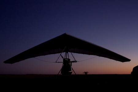 evening silhouette of a hang-glider on the ground after useの写真素材