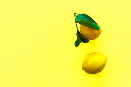 two whole lemons on light yellow background, shallow DOFの写真素材