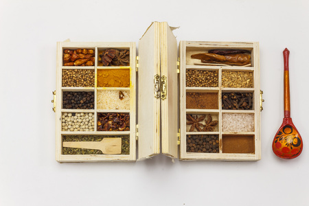 Assortment of spices in wooden box on whie backgroundの写真素材