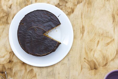 Sliced tasty chocolate cake on wooden table backgroundの写真素材