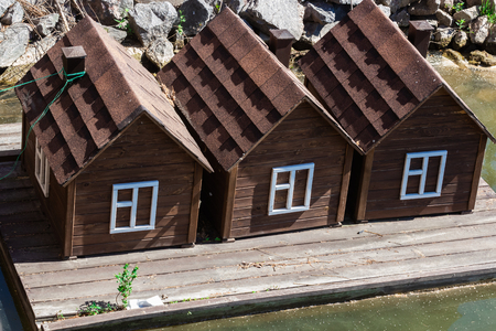 Wooden houses for swans on a lake in city parkの写真素材