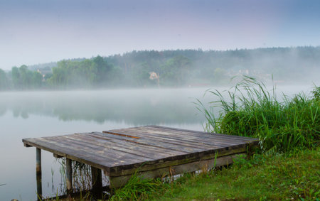 mystic fog is running on the lake in the cold summer morning. Bridge Lakeの写真素材