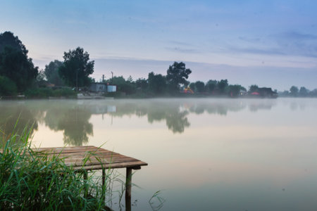 mystic fog is running on the lake in the cold summer morning. Bridge Lakeの写真素材