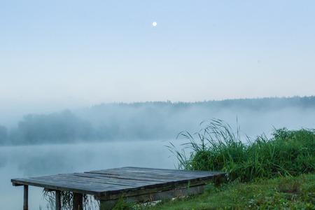 mystic fog is running on the lake in the cold summer morning. Bridge Lakeの写真素材