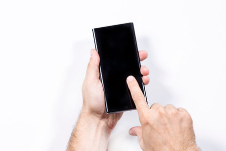 Man holding smartphone on white background, closeup of hand. isolated