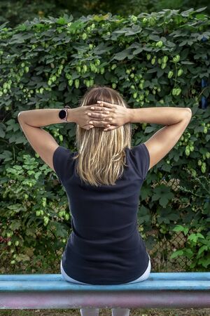 European young girl with blond hair old doing physical exercises on a sunny. Watchの写真素材
