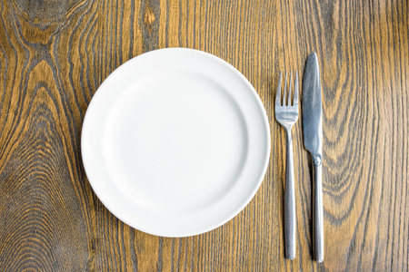empty plate with fork and knife on the vintage wooden table