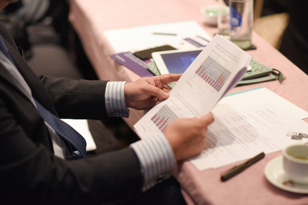 Close-up Of Businessman Holding Document At Deskの写真素材