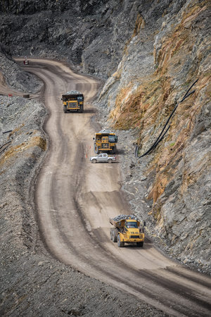 Open pit mine industry, big yellow mining truck for coal anthracite.