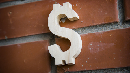 Wooden dollar symbol on brick wall backgroundの写真素材