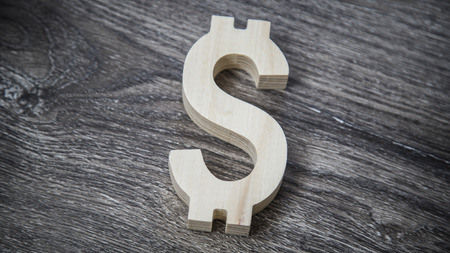 Dollar symbol on dark wooden wall backgroundの写真素材