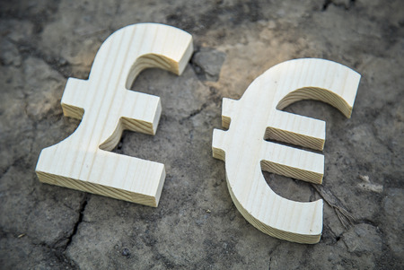 Exchange currency euro and pound on a dry land. Wooden sign.の写真素材