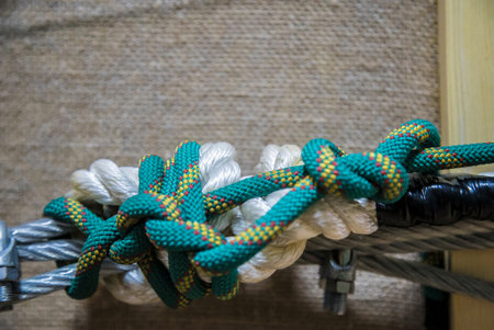 Ship ropes with knot on blurred wooden background