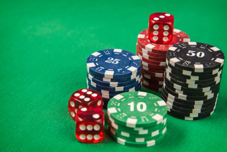 Gambling chips, red dice on green card table background