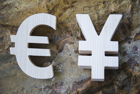 Exchange currency unit on a rock background. Wooden sign.の写真素材