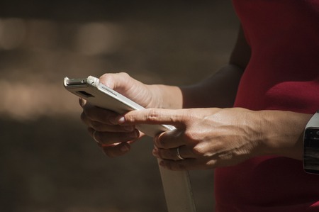 Woman outdoors using her smartphone and smartwatchの写真素材