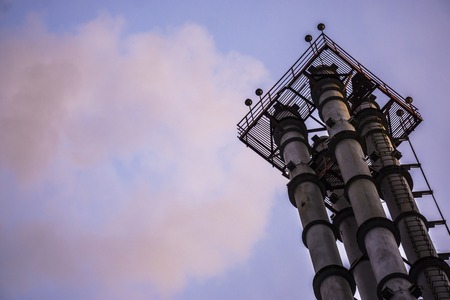 Smoking chimneys of the factory on blue sky backgroundの写真素材