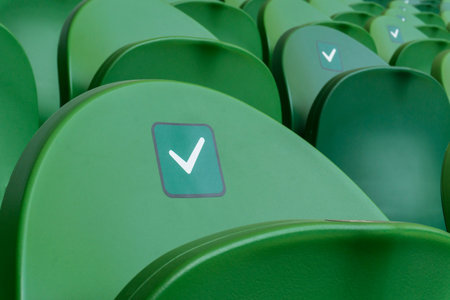 Empty plastic seats in a stadium. Stickers intended to promote social distancing in the arena.の写真素材