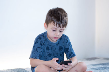 Child boy Playing with a smartphone with white background