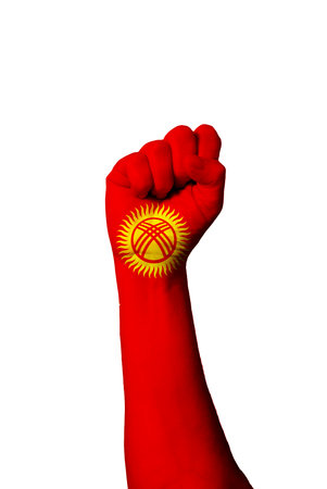Flag of Kyrgystan painted on human fist. Strength, power, concept of conflict. Raised fist.の写真素材
