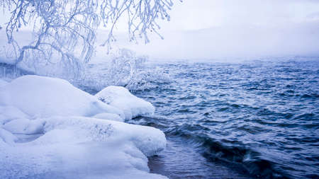 Winter scene in Russia by the lake - water, mist, snow forest and mountainsの写真素材
