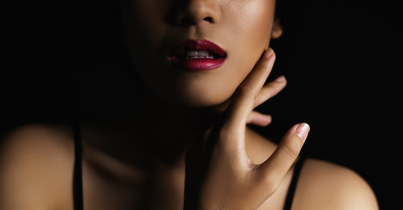 beautiful woman's face From nose to chest Showing lips And clean, healthy glossy skin cleared under low key conceptの写真素材