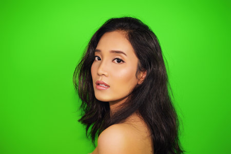 The side of an asian beautiful woman with perfect skin, clean eyes The model of beauty models with natural makeup On a green backgroundの写真素材