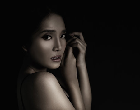 beautiful young woman closeup face and glossy skin under glamour low key conceptの写真素材