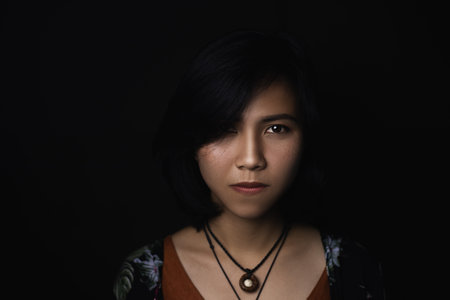 Asian short black haired woman Wearing jewelry made of leather and stone On her face, there is a...