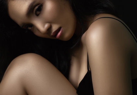 beautiful young woman closeup face and glossy skin under glamour low key conceptの写真素材