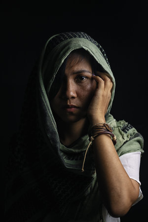 woman with freckles on the face Wearing a headdress and scarf with ornaments made of leather and rings On a black background and shadowsの写真素材