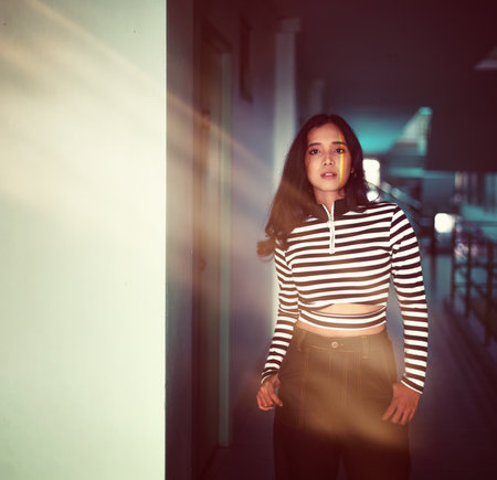 The woman standing near a window had light leak sparkling lightの写真素材