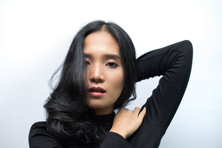Woman with black curly hair Wearing a black turtleneck sweater Poses shooting on a white backgroundの写真素材